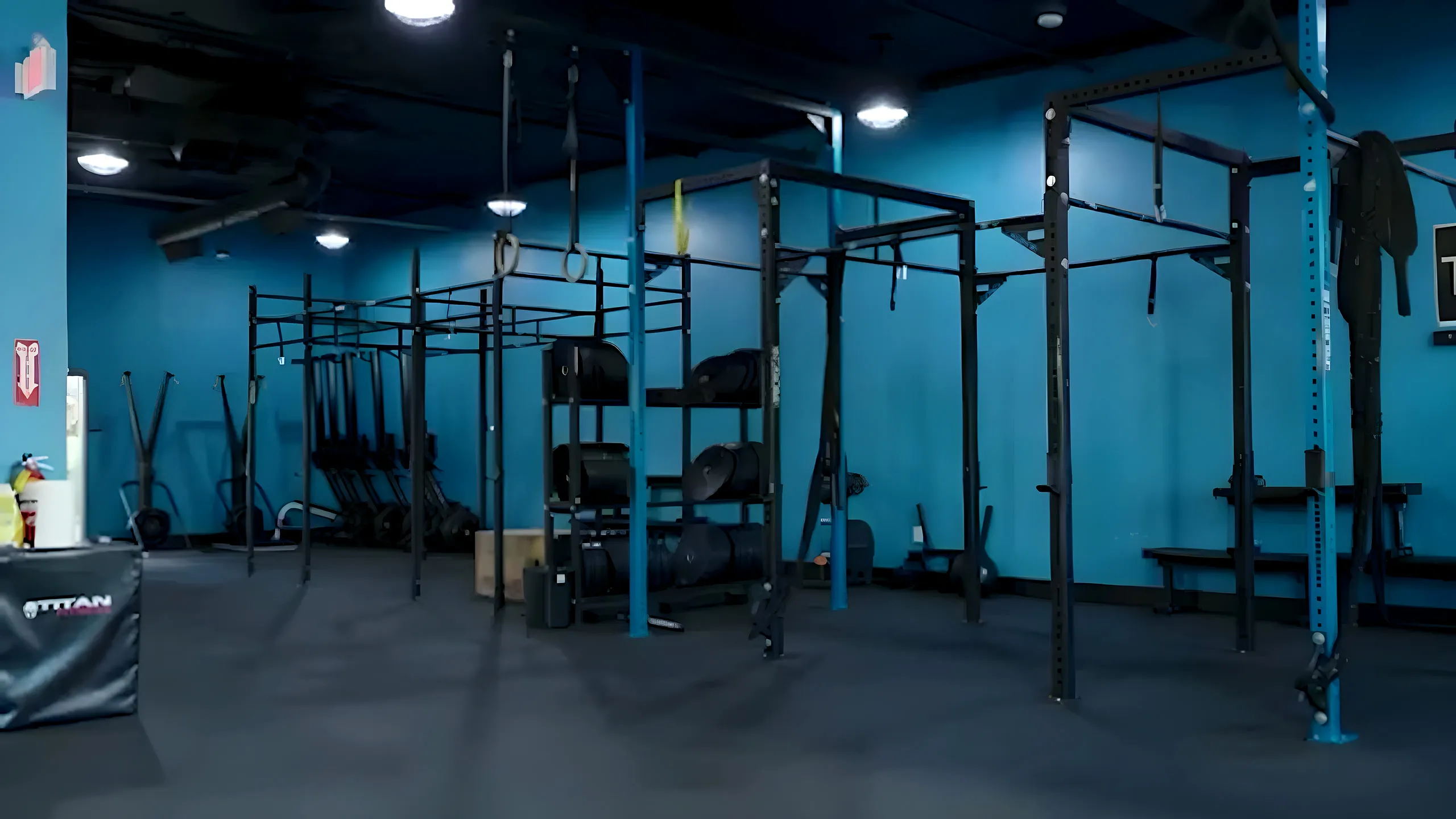 The strength training floor at Title 29 Fitness — squat rigs, rings, and plate storage
