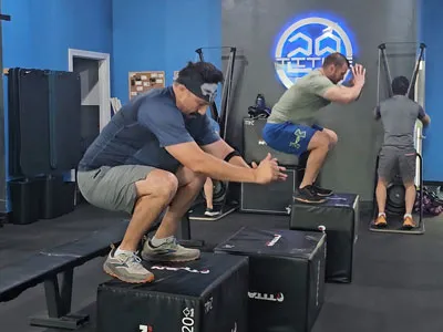Members doing box jumps in a class at Title 29 Fitness